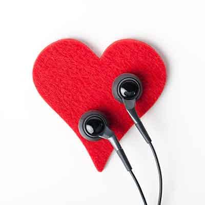 Un corazón rojo de fieltro con unos auriculares encima, como si lo escucharan